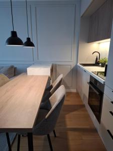 Una cocina con una mesa y sillas de madera. en Sparkle Home, en Banja Luka