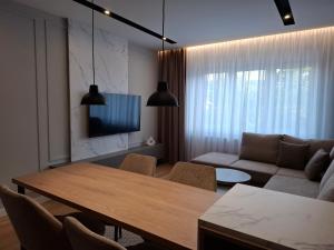 una sala de estar con una mesa y un sofá en Sparkle Home, en Banja Luka