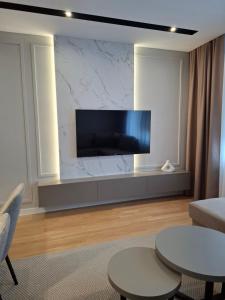 Una sala de estar con un televisor de pantalla plana en una pared. en Sparkle Home, en Banja Luka 18 fotos más