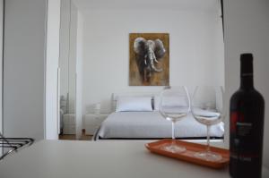 a bedroom with a bottle of wine and two wine glasses at Marimar Apartment in Bari