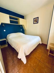 una camera con un letto bianco e una parete blu di T2 Lacanau - Cosy au calme sur le golf & Océan a Lacanau Altre 19 foto