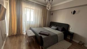 a bedroom with a bed and a couch and a window at Georgiana’s central apartment in Buzău