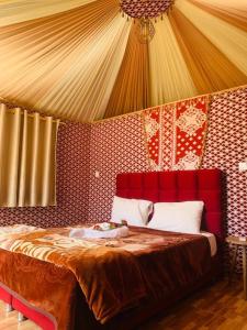 a bedroom with a red bed in a tent at WADI RUM-Bedouin Tents and Jeep Tours in Wadi Rum