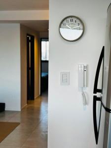 a clock on a wall next to a hallway at Center Suites fantastico in La Plata