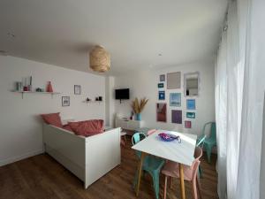 a living room with a couch and a table at Appartements - Riva Bella in Ouistreham