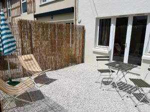 a patio with chairs and a table and a fence at Appartements - Riva Bella in Ouistreham