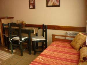 a room with a table and chairs and a bed at Apart Hotel Bungalows Los Cipresales in San Carlos de Bariloche