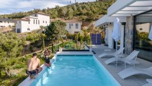 two men standing in a swimming pool in a house at Suite 28 in Treilles