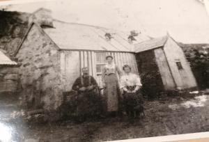 an old photo of three people standing in front of a house at Eco Crofter's Wagon by the Sea - Off Grid Experience - No electricity - As seen soon on Netflix in Oldshoremore