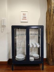 ein schwarzer Schrank voller Teller und Schüsseln in der Unterkunft Cornerstone, apartamento en Casco Viejo in Bilbao
