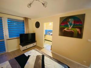 a living room with a bed and a flat screen tv at Apartament Golden Five in Mielec