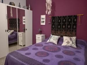 a bedroom with purple walls and a bed with pillows at lo flamenc @Amposta in Amposta