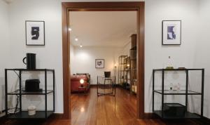 einen Flur mit Spiegel und ein Wohnzimmer in der Unterkunft Cornerstone, apartamento en Casco Viejo in Bilbao