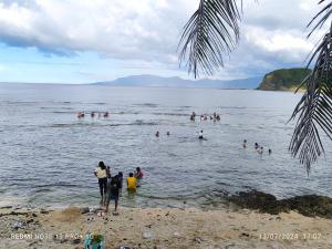 a group of people in the water at the beach at Ocean View Room Jay Henry's Transient House in Pagudpud