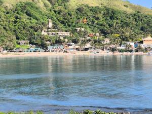 a body of water with a beach and a town at Ocean View Room Jay Henry's Transient House in Pagudpud