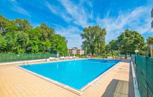 a large swimming pool with chairs and a fence at La Dolce Vita - Apartment with shared pool and large terrace in Lido delle Nazioni