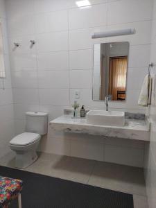 a bathroom with a toilet and a sink and a mirror at Huluan Alto da Boa Vista in Campos do Jordão +11 photos