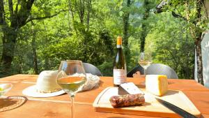 a wooden table with a bottle of wine and cheese at Juaniz in Tolmin