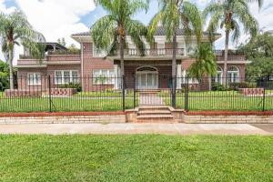 a house with a fence and palm trees at LUXURY 6000 sqft Mansion in Downtown Orlando Sleeps 12 in Orlando