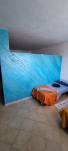 a bedroom with a blue wall with a bed in it at La Costa in Arzachena