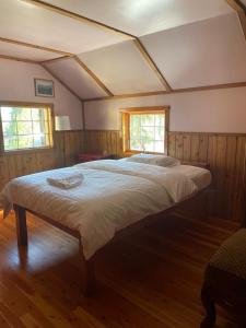 a large bed in a room with two windows at Rustic Beaverfoot Lodge Room N10 in Parson +36 photos