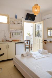a white kitchen with a large bed in a room at ASTYSTUDIO in Astypalaia