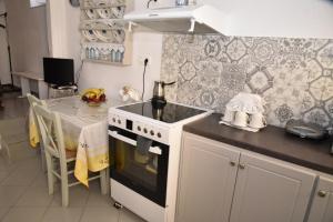 a kitchen with a stove and a table in it at Venti Home in Ano Syros
