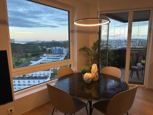 a dining room with a table and chairs and a large window at ONS 2024 apartment for rent - panoramic view, private gym,parking - close to city centre in Stavanger