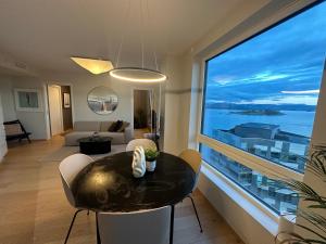 a living room with a table and a large window at ONS 2024 apartment for rent - panoramic view, private gym,parking - close to city centre in Stavanger +4 photos