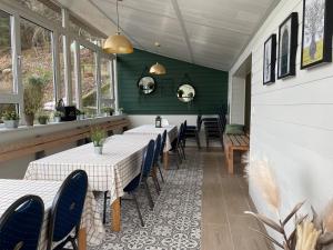 a restaurant with tables and chairs and green walls at Vakantiehuis Perles de la cascade in Stavelot