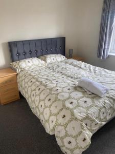 a bedroom with a large bed with a black headboard at Mesnes Place in Wigan