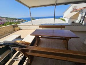 two picnic tables on a balcony with a view of the ocean at Apartments Villa Šibenik in Primošten