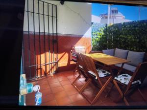 a wooden table and chairs on a balcony at PORTIL Con Amor in El Portil