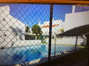 a view of a swimming pool through a chain link fence at PORTIL Con Amor in El Portil