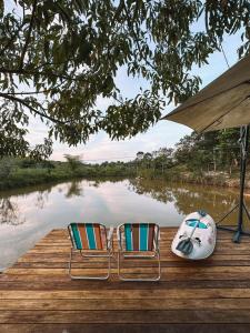 two chairs on a dock next to a body of water at Hospedagem Ônibus na Roça em Serra ES in Serra +49 photos