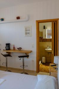 a room with a bed and a table and two bar stools at ASTYSTUDIO in Astypalaia