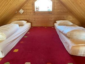 2 camas en una habitación con alfombra roja en Vilppulan Huvila, en Suluslahti