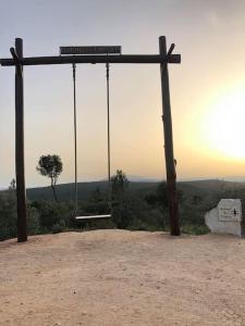 a swing on the top of a hill with the sunset at Casa na Aldeia in Alburitel