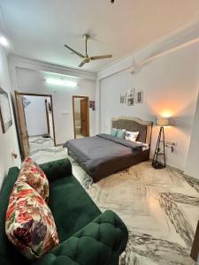 een slaapkamer met een bed en een bank bij The Cozy Nook in Udaipur