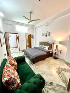 een slaapkamer met een bed en een groene bank bij The Cozy Nook in Udaipur