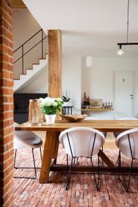 a dining room with a wooden table and chairs at B&B O-Lit in Paal