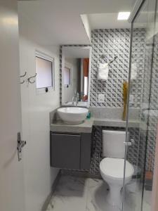 a bathroom with a white toilet and a sink at Apartamento Mania Terceiro Andar in Vitória