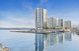 a group of tall buildings with cars parked at a dock at ONS 2024 apartment for rent - panoramic view, private gym,parking - close to city centre in Stavanger