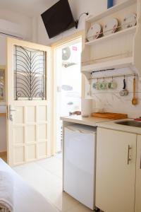 a kitchen with white cabinets and a door at ASTYSTUDIO in Astypalaia +34 photos