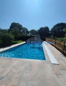 a swimming pool at a resort with blue water at PISCINA CLIMATIZADA - todo el año- Playa de la Ñora-chimenea- barbacoa in Quintueles