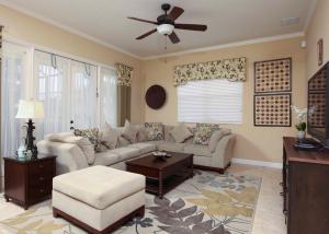 a living room with a couch and a ceiling fan at Luxury Villa 5 Bedrooms Minutes from Disney in the Reunion resort in Kissimmee