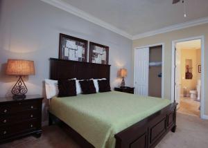 a bedroom with a large bed with a green bedspread at Luxury Villa 5 Bedrooms Minutes from Disney in the Reunion resort in Kissimmee +48 photos