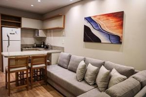 een woonkamer met een bank en een keuken bij Lindo flat no Serra Class in Canela