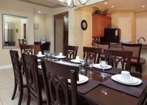 a dining room with a table and chairs with wine glasses at Luxury Villa 5 Bedrooms Minutes from Disney in the Reunion resort in Kissimmee