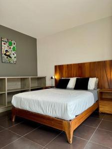 a bedroom with a large bed with a wooden headboard at AC Andares Tec Nespresso Estacionamiento Gratis 4p in Guadalajara